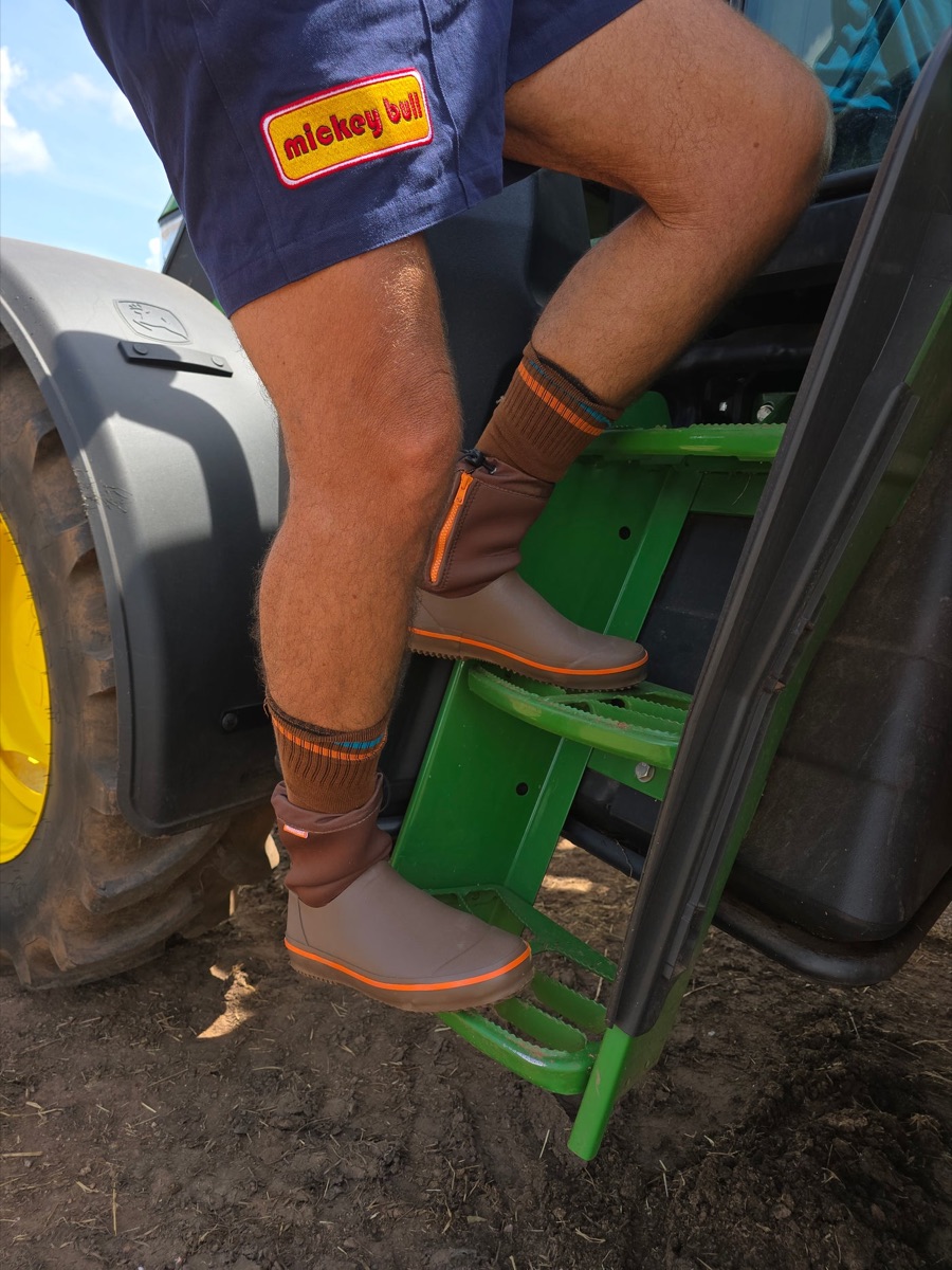 Climbing into a tractor cab wearing Mudcrabz